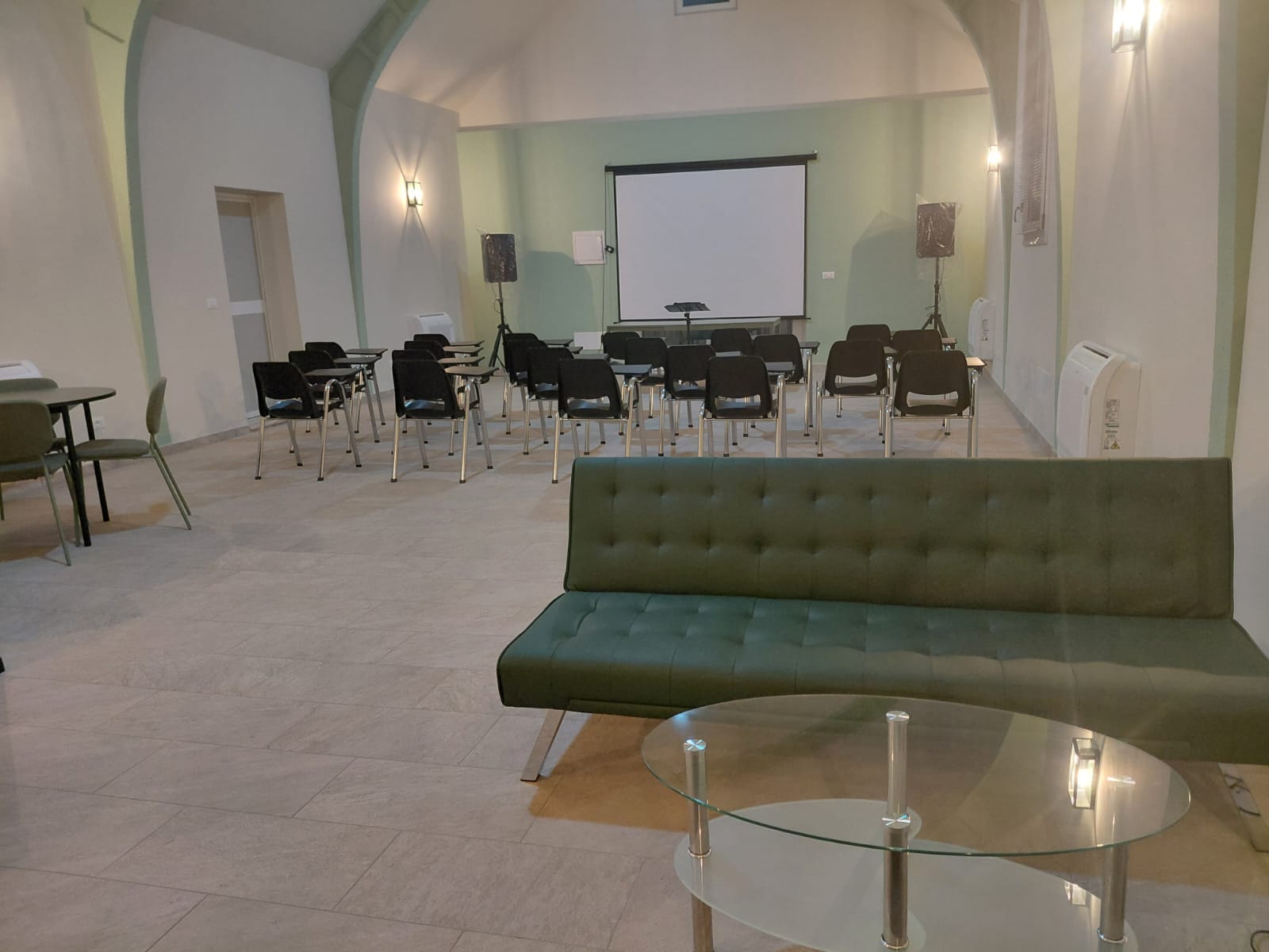 Sala interna di Amor Cani con area lounge e schermo per proiezioni